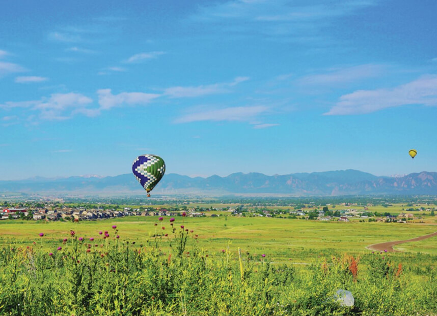 Hot air balloon flying over Fort Collins field